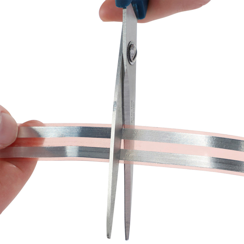 Close-up of scissors cutting a Kerbl Snail Stop contact strip to size for installation around raised garden beds, planters, and pots to help deter snails and slugs.